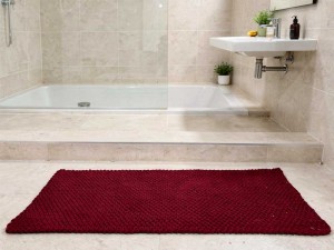 Bordowy dywanik łazienkowy.