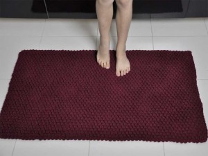 Bordowy dywanik łazienkowy.