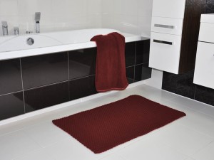 Bordowy dywanik łazienkowy.