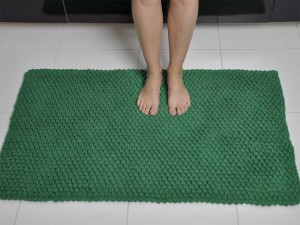 Zielony dywanik łazienkowy.