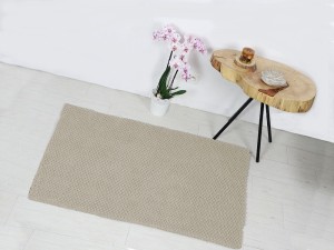 Bawełniany dywanik łazienkowy w kolorze ecru.