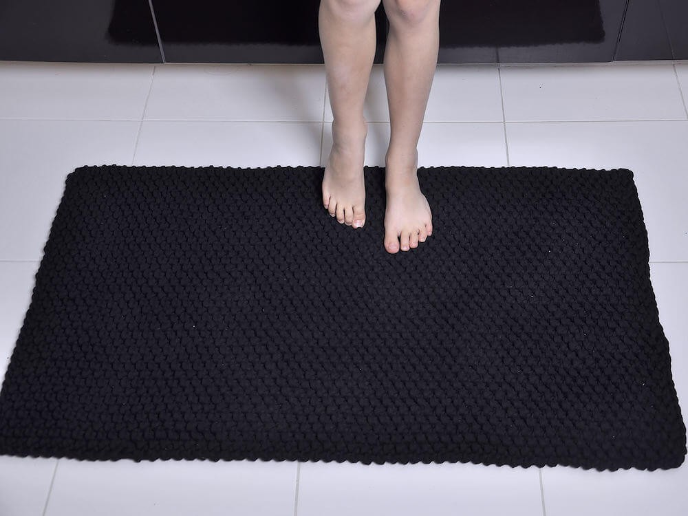 Czarny, bawełniany dywanik łazienkowy.