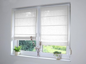 Białe, lniane rolety rzymskie.