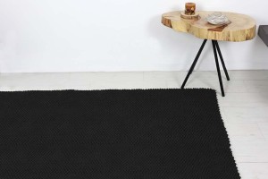 Czarny, bawełniany dywan do sypialni lub salonu.