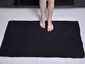 Czarny, bawełniany dywan do sypialni lub salonu.